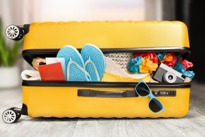 AYellowOpenSuitcaseWithThingsLyingOnTheFloor - Mann Travel